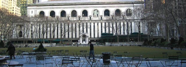 Tables in Bryant Park and the rear of the NYPL on a rainy day.